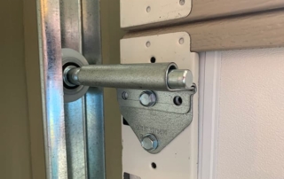 Closeup picture of garage door roller and track.