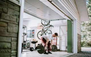 Man working out in garage with weights.