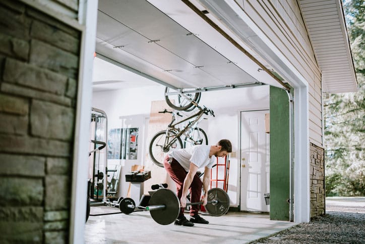 Man working out in garage with weights.