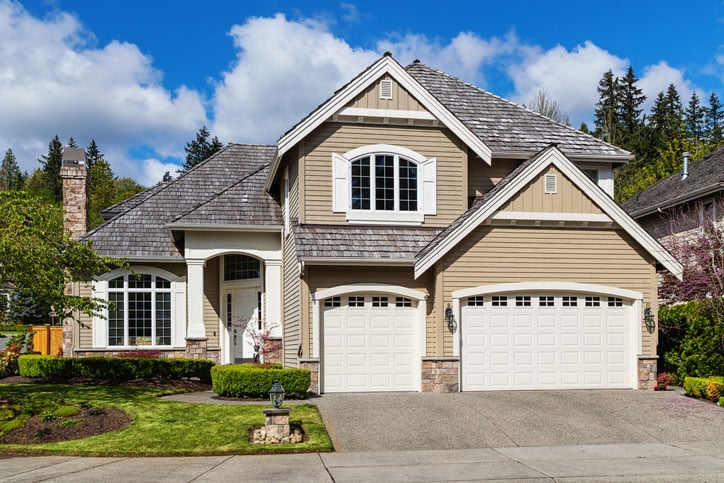 Photo of a modern suburban home exterior with new garage door that is boosting home value