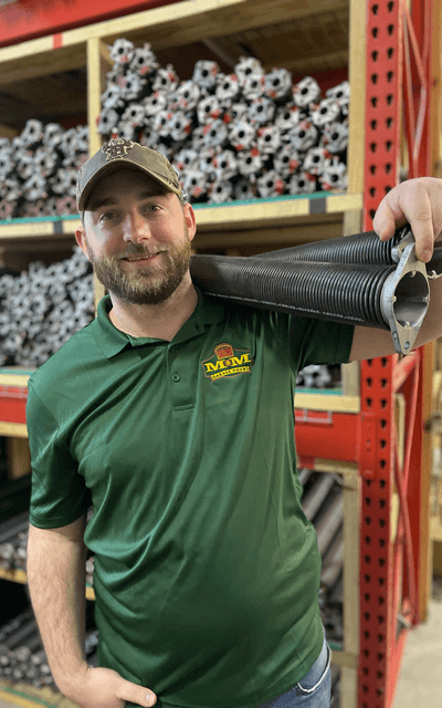 M&M Garage Doors technician holding a garage door spring